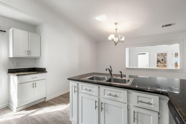 kitchen with a sink, visible vents, baseboards, white cabinets, and light wood finished floors