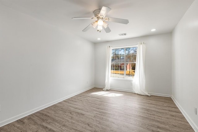 spare room featuring recessed lighting, wood finished floors, a ceiling fan, visible vents, and baseboards