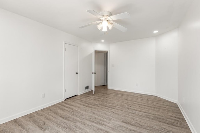 unfurnished room featuring recessed lighting, wood finished floors, a ceiling fan, and baseboards