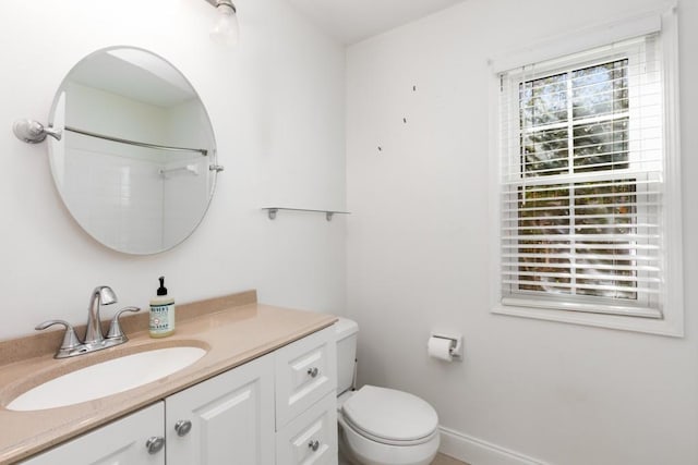 bathroom featuring baseboards, vanity, and toilet