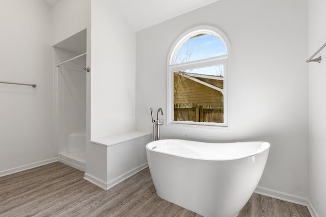 full bath with a freestanding tub, baseboards, walk in shower, and wood finished floors