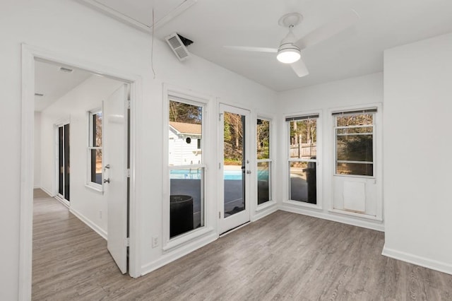 unfurnished sunroom featuring visible vents and ceiling fan