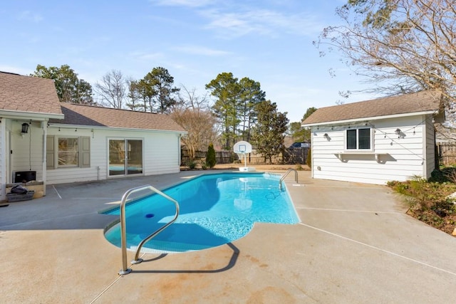 view of swimming pool with a patio, an outdoor structure, fence, and a fenced in pool