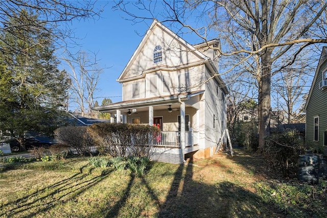 view of front facade with a porch, a front yard, and a ceiling fan