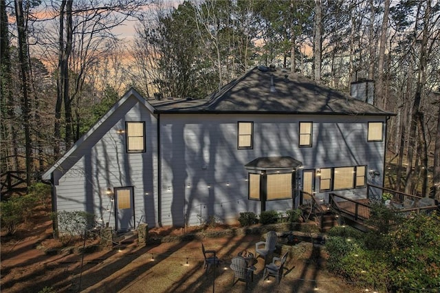 back of house with a chimney