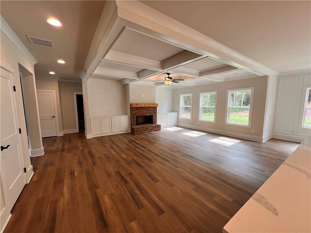 unfurnished living room with coffered ceiling, beam ceiling, ceiling fan, a fireplace, and dark hardwood / wood-style flooring