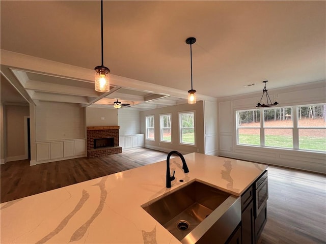 kitchen with dark wood-type flooring, a wealth of natural light, pendant lighting, and sink