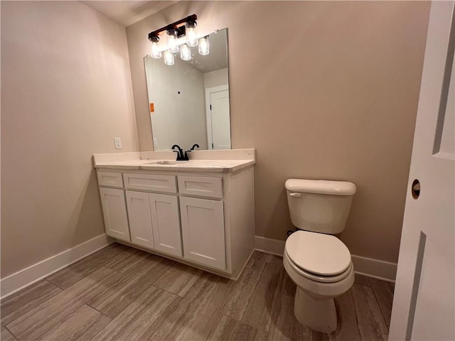 bathroom with vanity, hardwood / wood-style flooring, and toilet