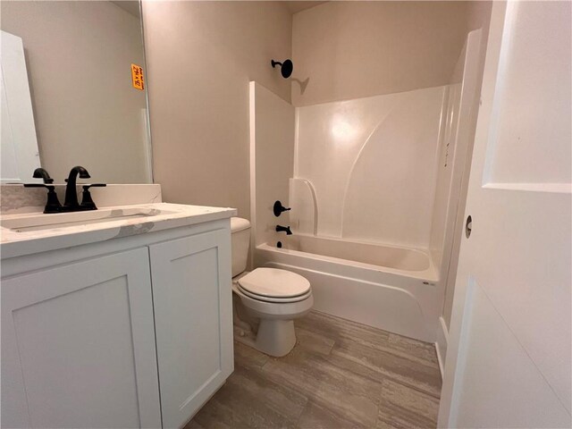 full bathroom featuring vanity, shower / bathing tub combination, hardwood / wood-style flooring, and toilet