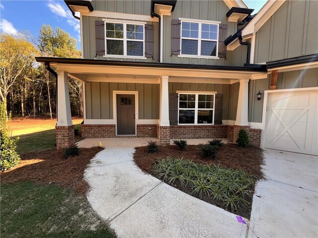 doorway to property with a porch and a garage