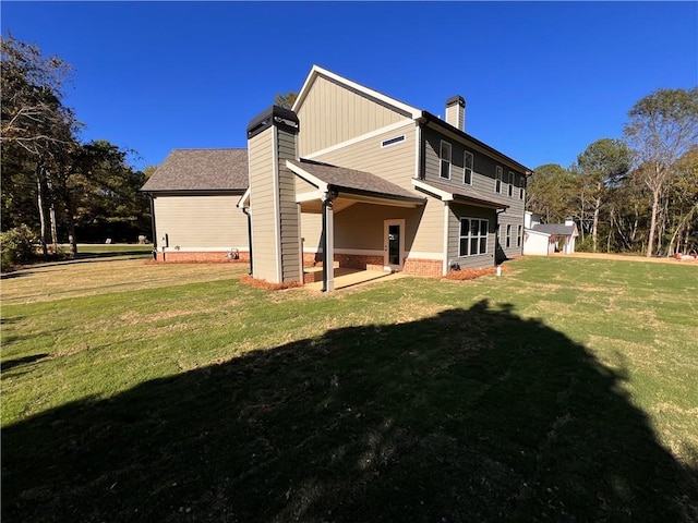 rear view of property featuring a patio area and a lawn