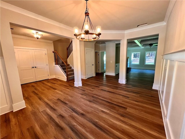 unfurnished dining area with crown molding, dark hardwood / wood-style floors, and an inviting chandelier