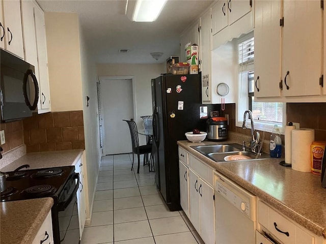 kitchen featuring light tile patterned floors, a sink, white cabinets, black appliances, and tasteful backsplash