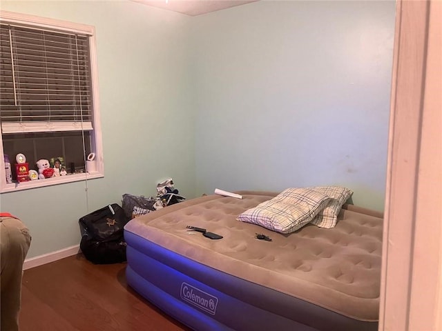 bedroom featuring baseboards and wood finished floors