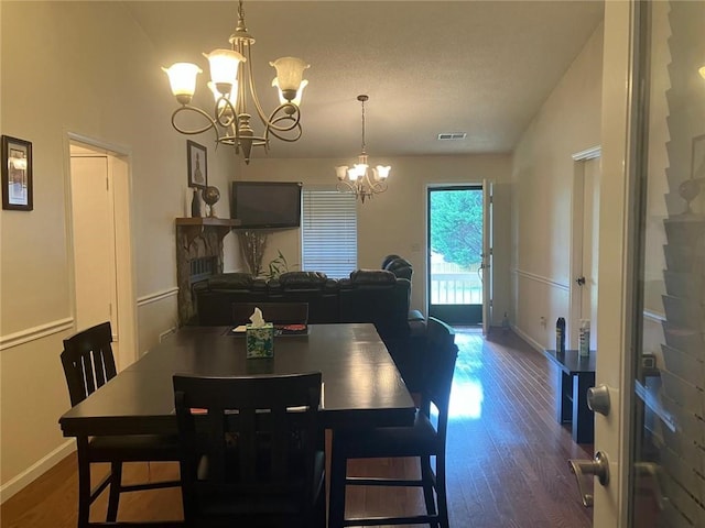 dining room featuring baseboards, visible vents, a chandelier, and dark wood-type flooring