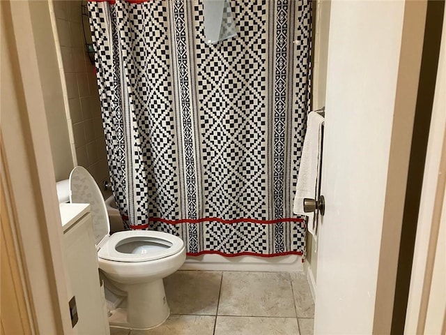 bathroom with shower / bath combo with shower curtain, toilet, and tile patterned floors