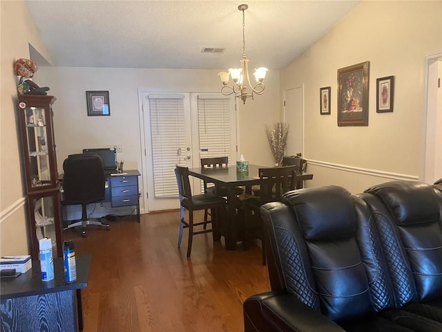 dining space with lofted ceiling, dark wood-style flooring, visible vents, and an inviting chandelier