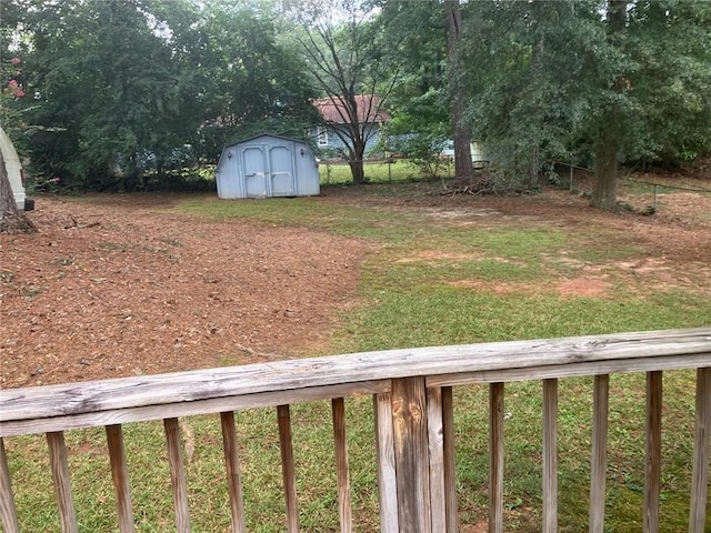 view of yard featuring a storage shed, an outdoor structure, and fence