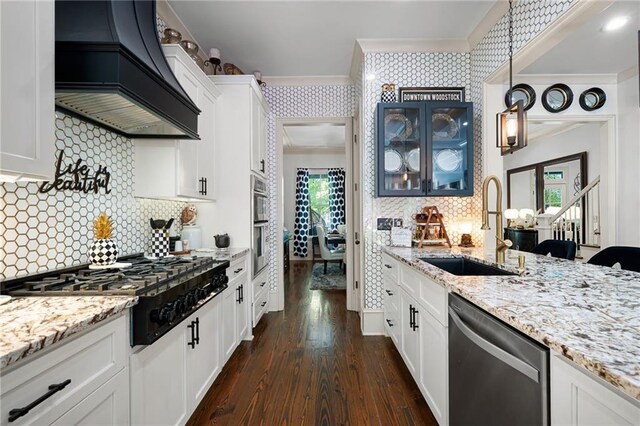 kitchen featuring crown molding, custom exhaust hood, stainless steel appliances, and white cabinets