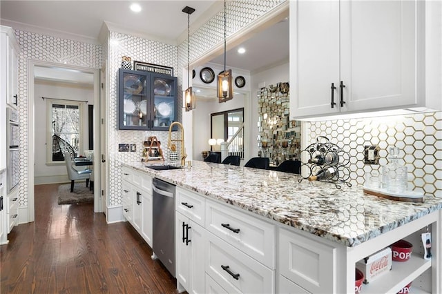 kitchen with decorative light fixtures, dishwasher, sink, white cabinets, and light stone countertops