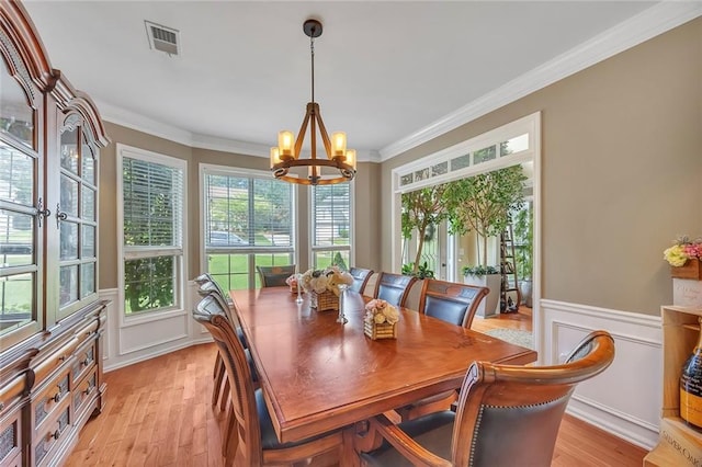 225 Ruby Forest Pkwy, Suwanee, GA 30024 - dining room with a chandelier, crown molding, light wood finished floors, a wainscoted wall, and a decorative wall