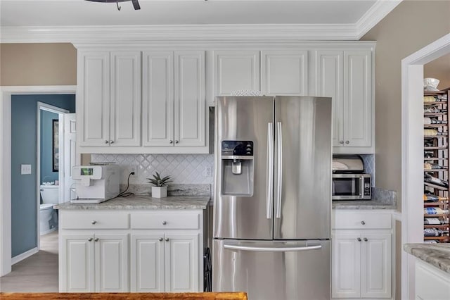 225 Ruby Forest Pkwy, Suwanee, GA 30024 - kitchen featuring stainless steel appliances, decorative backsplash, white cabinetry, and crown molding
