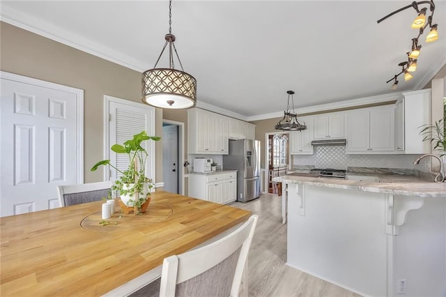 225 Ruby Forest Pkwy, Suwanee, GA 30024 - kitchen with stainless steel refrigerator with ice dispenser, a peninsula, white cabinetry, light wood finished floors, and ornamental molding