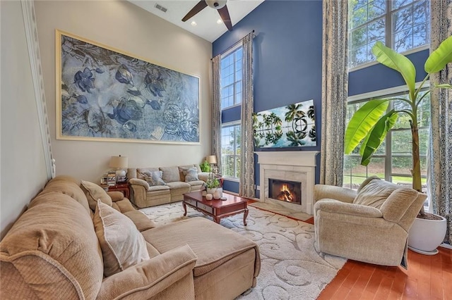 225 Ruby Forest Pkwy, Suwanee, GA 30024 - living area featuring ceiling fan, wood finished floors, a fireplace, and a high ceiling