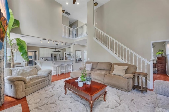 225 Ruby Forest Pkwy, Suwanee, GA 30024 - living area featuring a high ceiling, light wood-type flooring, stairs, and recessed lighting