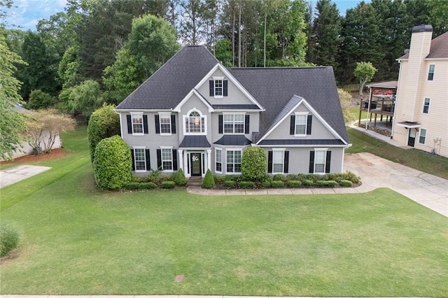 225 Ruby Forest Pkwy, Suwanee, GA 30024 - colonial house featuring a standing seam roof, a front lawn, a metal roof, a shingled roof, and concrete driveway