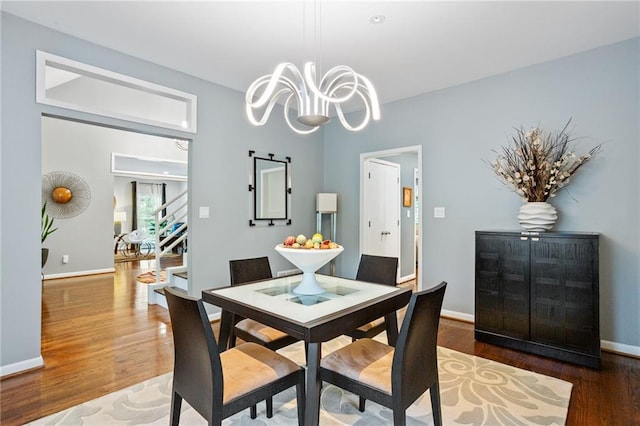 dining area featuring a notable chandelier and dark hardwood / wood-style floors