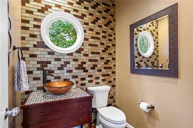 bathroom featuring tasteful backsplash, vanity, and toilet