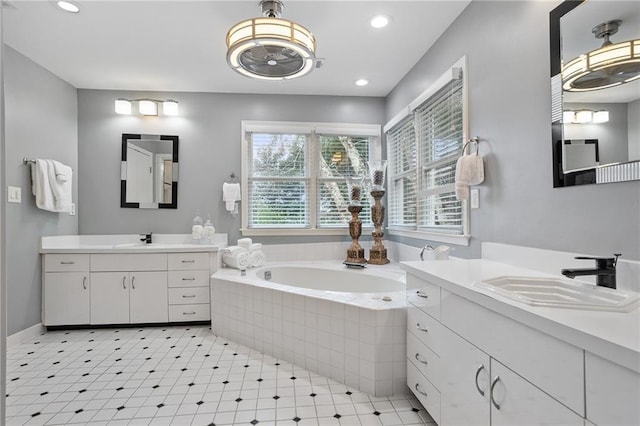 bathroom featuring vanity and tiled bath