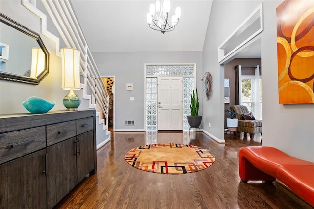 entryway featuring dark hardwood / wood-style flooring, vaulted ceiling, and an inviting chandelier