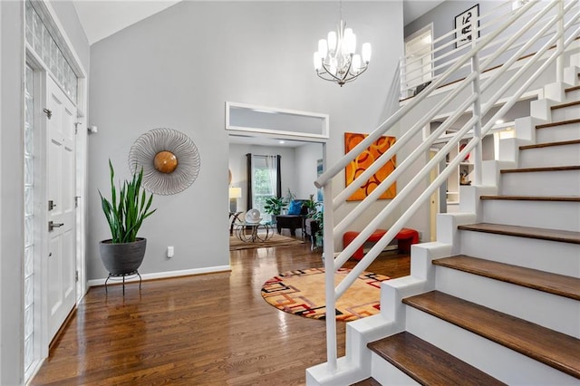 entrance foyer with dark wood-type flooring, a high ceiling, and an inviting chandelier