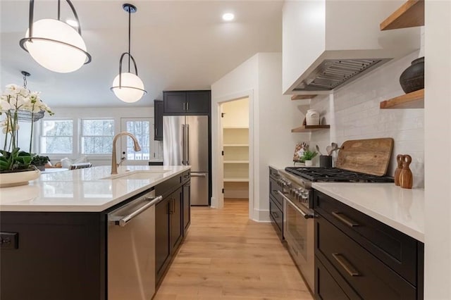 kitchen with backsplash, ventilation hood, sink, decorative light fixtures, and high quality appliances