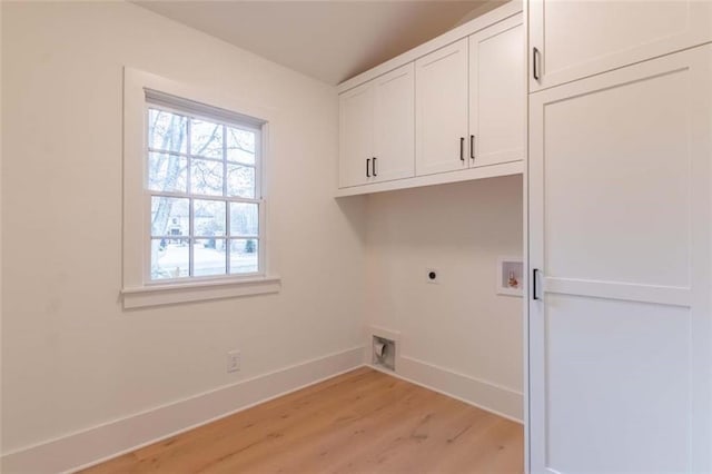 clothes washing area with hookup for an electric dryer, cabinets, light wood-type flooring, and hookup for a washing machine