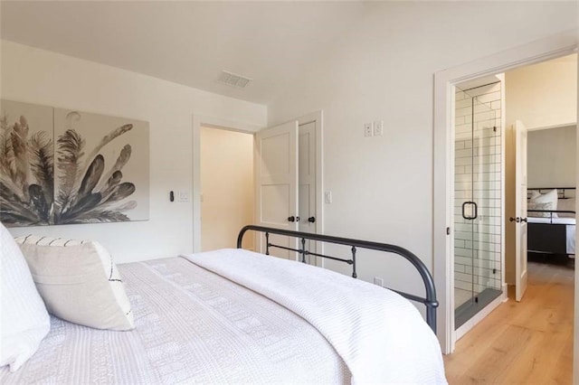 bedroom featuring ensuite bathroom and light hardwood / wood-style flooring