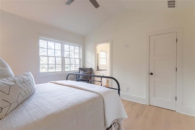 bedroom featuring ceiling fan, light hardwood / wood-style flooring, and lofted ceiling