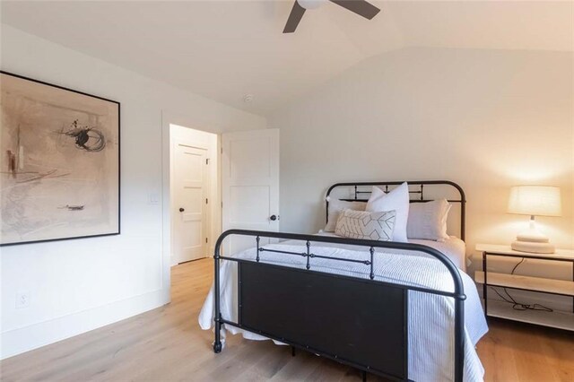 bedroom with vaulted ceiling, light hardwood / wood-style flooring, and ceiling fan