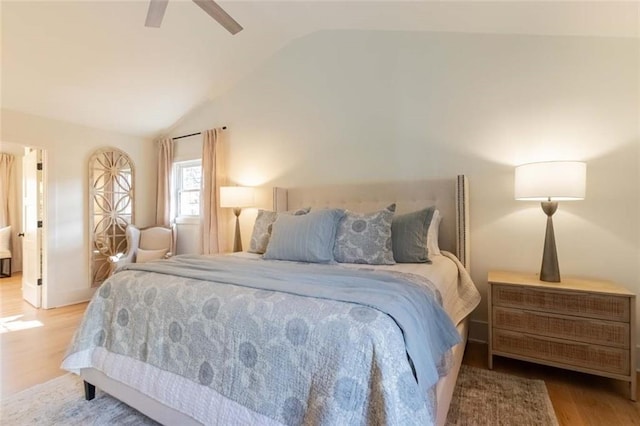 bedroom featuring ceiling fan, light hardwood / wood-style floors, and lofted ceiling