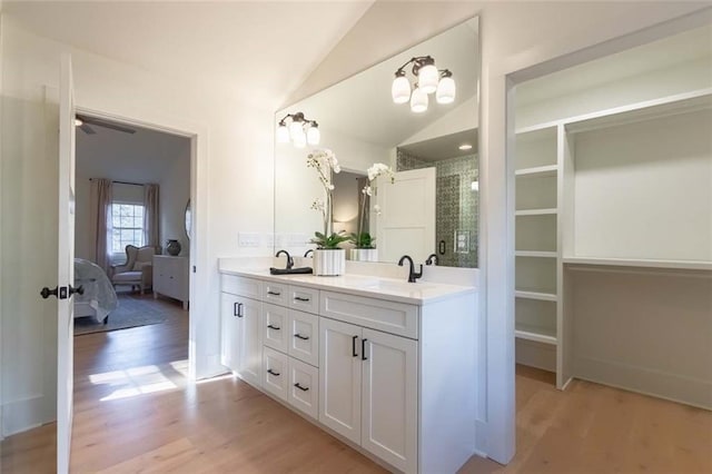 bathroom featuring ceiling fan, vanity, vaulted ceiling, and hardwood / wood-style flooring