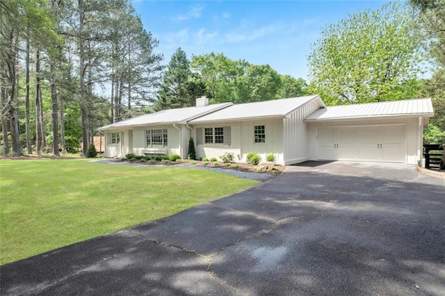 ranch-style house featuring a garage and a front lawn