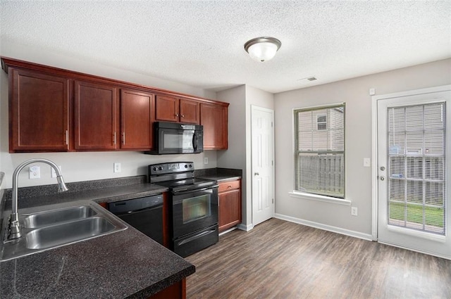 222 Ben Ln, Fairburn, GA 30213 - kitchen featuring black appliances, a sink, dark countertops, dark wood-style flooring, and a textured ceiling