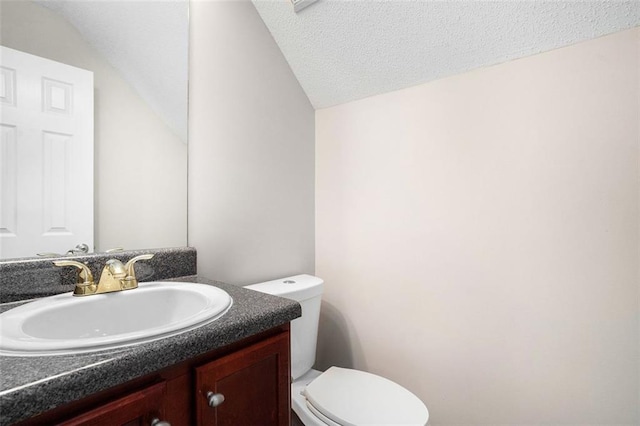 222 Ben Ln, Fairburn, GA 30213 - bathroom featuring lofted ceiling, toilet, vanity, and a textured ceiling