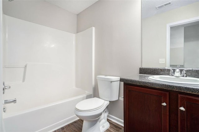 222 Ben Ln, Fairburn, GA 30213 - full bath featuring wood finished floors, toilet, vanity, and washtub / shower combination