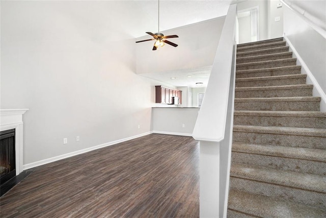 222 Ben Ln, Fairburn, GA 30213 - unfurnished living room featuring stairway, dark wood-type flooring, a ceiling fan, a fireplace, and baseboards
