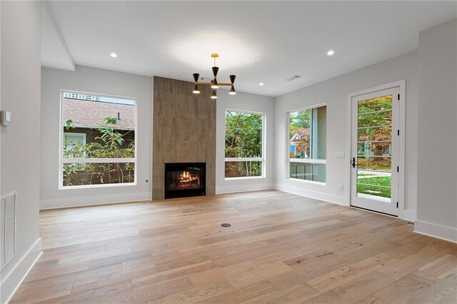 kitchen with light hardwood / wood-style flooring, a breakfast bar, hanging light fixtures, stainless steel appliances, and a center island with sink