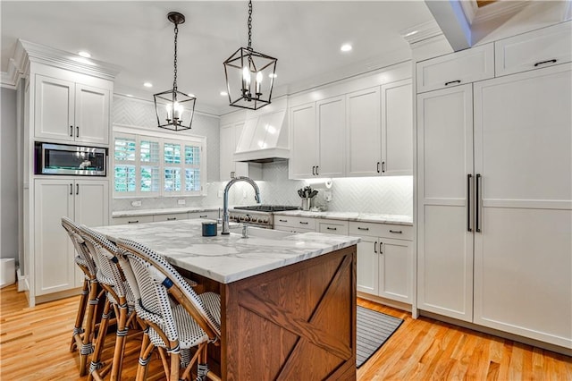 1658 E Clifton Rd NE, Atlanta, GA 30307 - kitchen featuring built in appliances, custom range hood, a chandelier, light wood-style floors, and recessed lighting