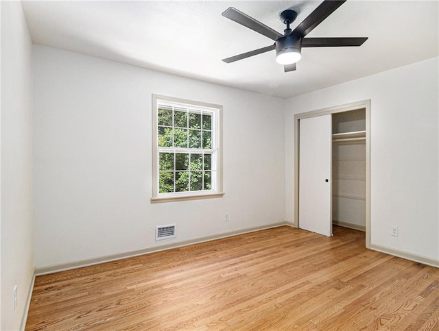 unfurnished bedroom with visible vents, light wood-style flooring, a ceiling fan, a closet, and baseboards